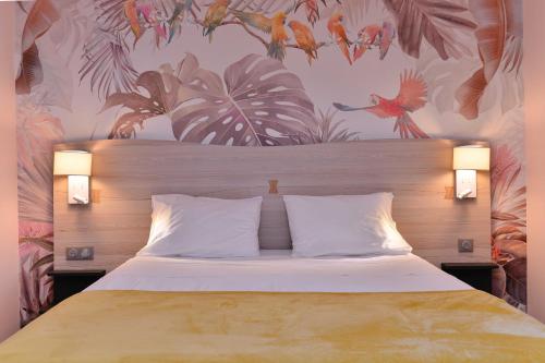 a bedroom with a bed with a tropical wallpaper at Logis Hôtel Restaurant Le Chêne Vert in Rocher