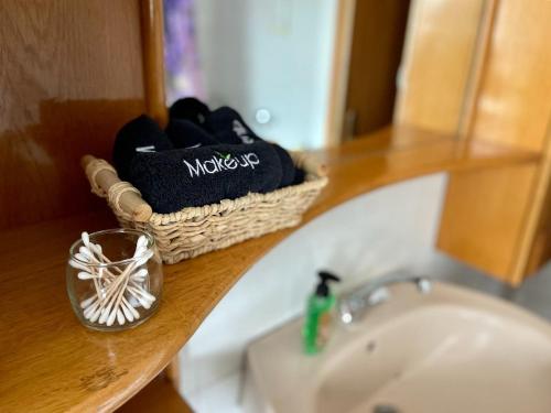 a bathroom counter with a sink and a basket of shoes at Prijeten prostoren apartma v hiši in Pivka