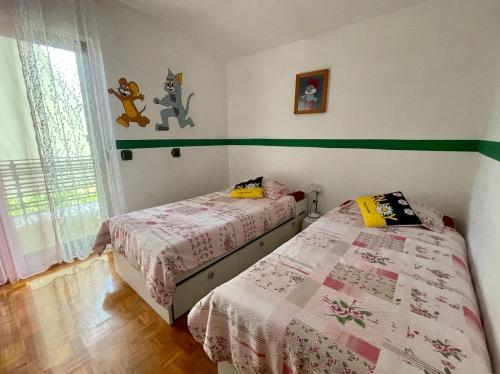 two beds in a bedroom with green and white walls at Prijeten prostoren apartma v hiši in Pivka