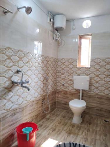 a bathroom with a toilet and a shower in it at Kurchi Homestay in Ghātsīla