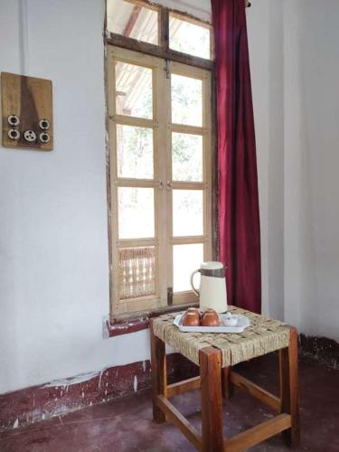 una mesa con una ventana y algo de fruta en ella en Kurchi Homestay, en Ghātsīla