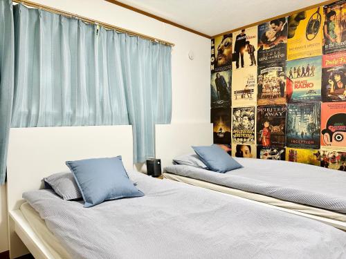 2 camas en una habitación con carteles en la pared en Shinjuku/Kabukichō｜Super Busy Area｜Cozy House｜85㎡, en Tokio
