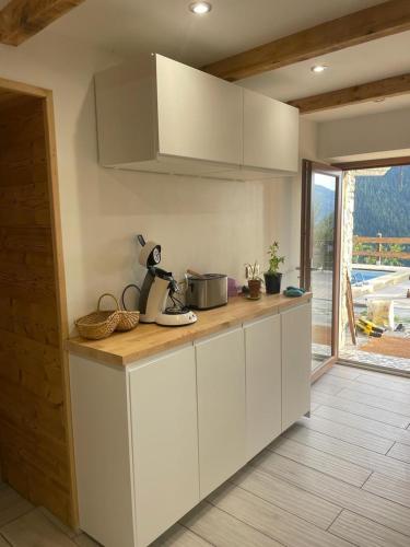 une cuisine avec des armoires blanches et un comptoir dans l'établissement Maison a Seez 170m2, à Séez