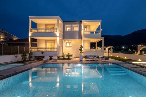 a villa with a swimming pool at night at Sole Mare in Chrysi Ammoudia
