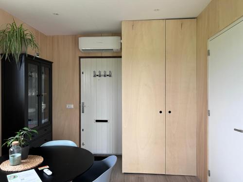 a living room with a cabinet and a table and a room at Blossombed in Voorhout