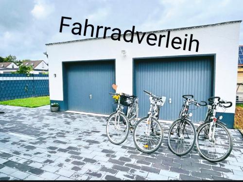 quatro bicicletas estacionadas em frente a um edifício em Pension zum Ahrblick em Sinzig