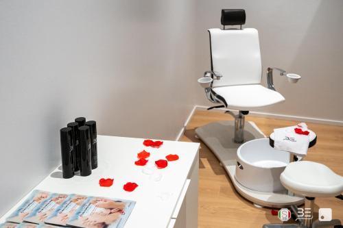 a room with a white table with red flowers on it at Palazzo Otello 1847 Wellness & Spa in Vicenza
