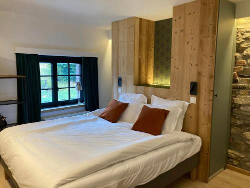 a large white bed in a room with a window at B&B La Bouliniere in Malmedy
