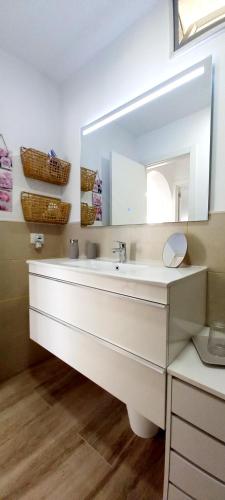 a bathroom with a white sink and a mirror at Ca Cristina "Scorpio" Puerto Rico in Puerto Rico de Gran Canaria