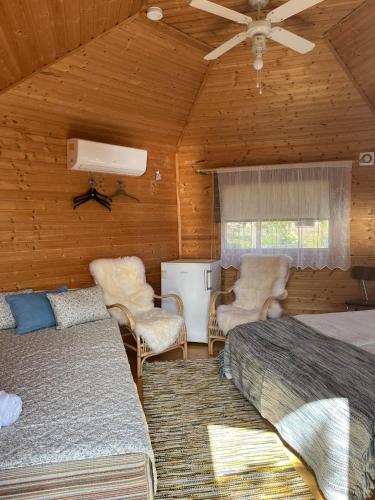 a bedroom with two beds and chairs in a room at Hortensia in Mariehamn