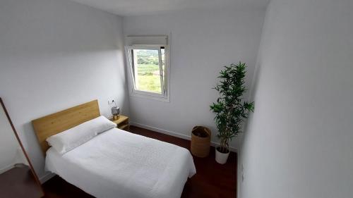 Habitación blanca con cama y ventana en Casa Oreiro Camiño dos faros Costa da Morte Ponteceso, en Ponteceso