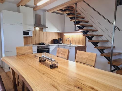 a kitchen with a wooden table and a staircase at G5 - Das Chalet am Waldrand in Sankt Stefan im Rosental