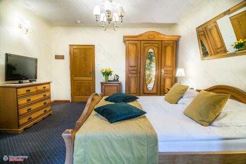sypialnia z 2 łóżkami, telewizorem i komodą w obiekcie Hotel Dwa Księżyce w Kazimierzu Dolnym