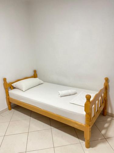 1 cama con marco de madera en una habitación en Apartments Vali, en Ulcinj