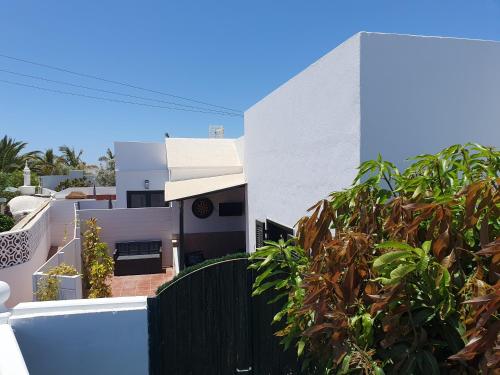 Uma casa branca com uma cerca preta à frente. em Casa El Eco del Volcán 1 em Teguise