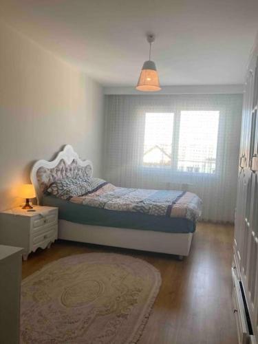 a bedroom with a bed and a window and a rug at 2+1. شقة فاخرة في بشاك شهير in Basaksehir