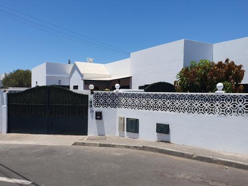 ein weißes Gebäude mit einem schwarzen Tor und einer Straße in der Unterkunft Casa El Eco del Volcán 2 in Teguise