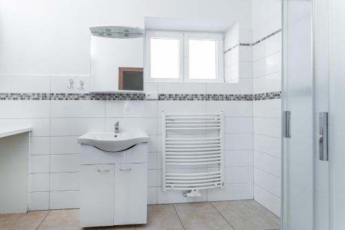 波傑布拉迪的住宿－Apartmán Riegrovo náměstí，白色的浴室设有水槽和窗户。