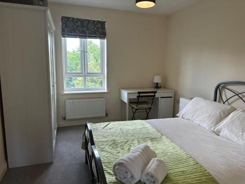 a bedroom with a bed and a window and a desk at Cosy 2 Bedrooms 2 Bathrooms in Basingstoke