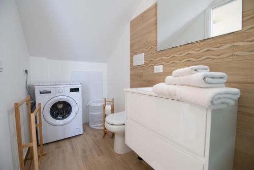 uma casa de banho com uma máquina de lavar roupa e uma máquina de lavar e secar roupa em Sveli em Marzamemi