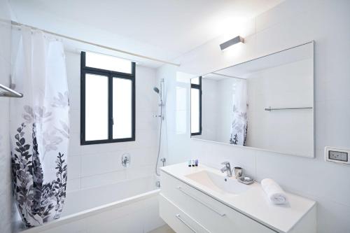 a white bathroom with a sink and a mirror at NOGA vibes 2BR in JAFFA by Holyguest in Tel Aviv