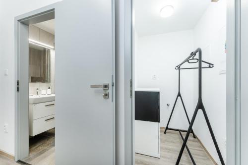a kitchen with white walls and a mirror at Apartmán v Poděbradech in Poděbrady