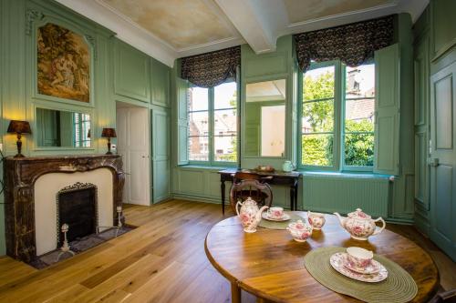 a living room with a table and a fireplace at La chambre de Manon in Hesdin