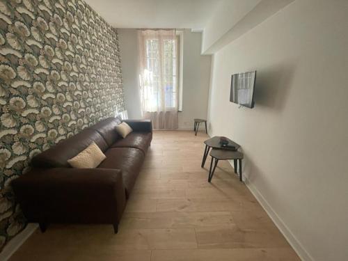 - un salon avec un canapé et un mur en pierre dans l'établissement Allée Paul Riquet - Cœur de ville, à Béziers