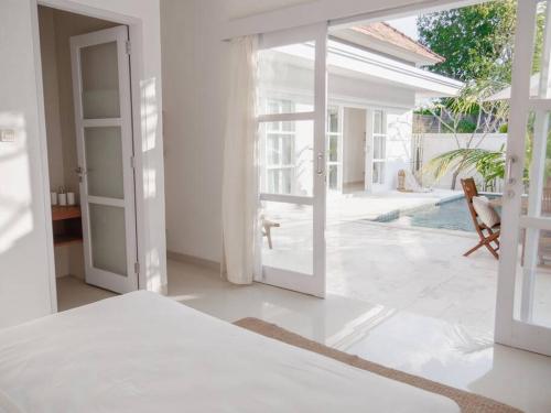 a white room with a door open to a patio at Casa Majorca at Ulu in Uluwatu