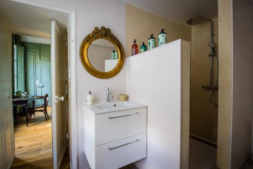 La salle de bains est pourvue d'un lavabo blanc et d'un miroir. dans l'établissement La chambre de Manon, à Hesdin