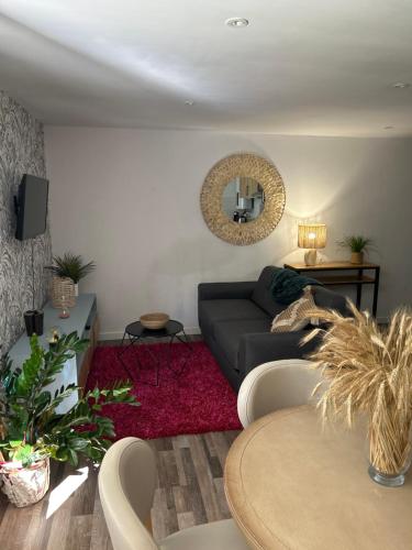 uma sala de estar com um sofá e um espelho em A louer appartement t2 em Espalion