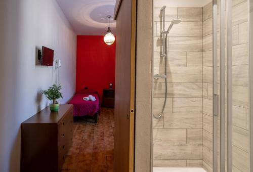 baño con ducha y pared roja en Albergo San Michele, en Tirano