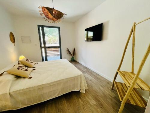 a bedroom with a bed and a television in it at Hôtel Résidence CAPENSE in Centuri