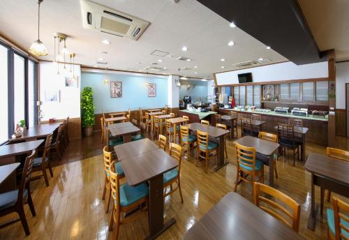 um restaurante com mesas e cadeiras e um bar em Country Hotel Takayama em Takayama