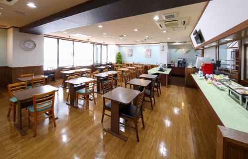 a restaurant with tables and chairs in a room at Country Hotel Takayama in Takayama