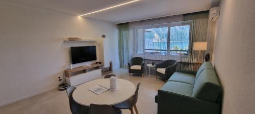 uma sala de estar com um sofá e uma mesa em Relax-Lugano Lake em Bissone