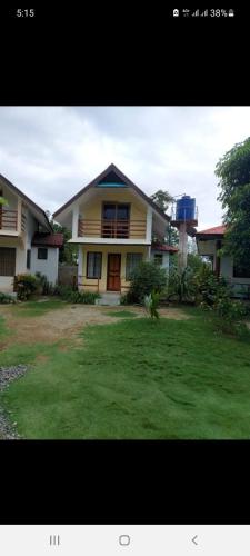 a large house with a lawn in front of it at Gardenview Homestay Siargao in General Luna