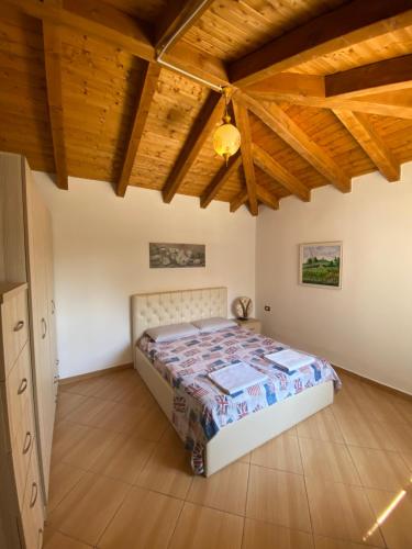 a bedroom with a bed in a room with wooden ceilings at Villa MINO in Shkodër