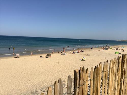 a group of people on a beach near the ocean at La Morandiere in Grayan-et-lʼHôpital
