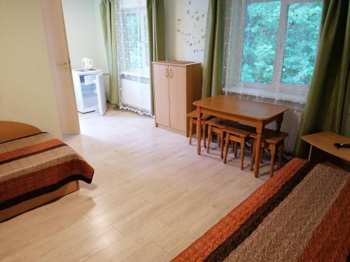 a bedroom with a table and a table and chairs at Svečių namai ALDAIVITA in Ignalina