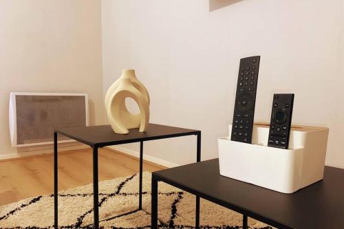 two black tables with a vase and two controllers at Les Grenats in Conflans-Sainte-Honorine