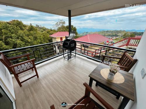 a balcony with a table and chairs on a balcony at Qloud Cottage in Ranau