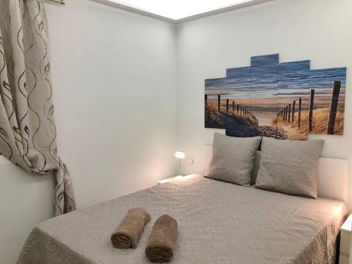 Un dormitorio con una cama con dos troncos. en Apartamento Birgitt en Aloha Garden con vista mar y piscina, en Adeje