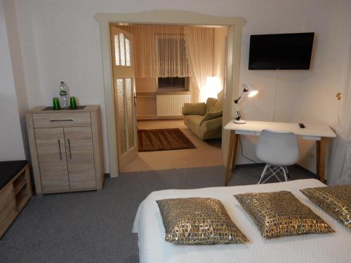 a bedroom with a bed and a desk and a room at Ferienwohnung Landhaus Hohenstein, Schwimmteich, ruhige Lage in Hessisch Oldendorf