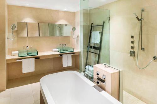 a bathroom with a shower and a toilet and a sink at The Westin Bayshore, Vancouver in Vancouver