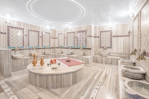 bagno con 4 lavandini e vasca di GRAND ANİ HOTEL a Kars