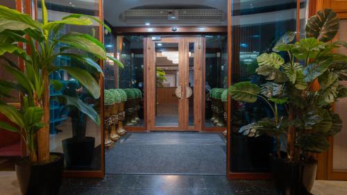 a hallway with potted plants and an open door at GRAND ANİ HOTEL in Kars