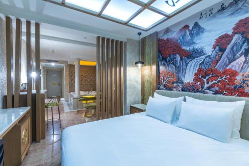 a bedroom with a large white bed and a painting on the wall at Wyndham Istanbul Old City in Istanbul