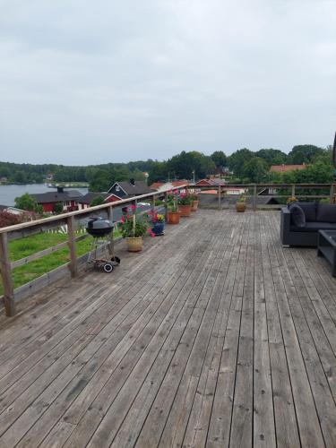 una terraza de madera con macetas. en Villa med sjöutsikt en Immeln