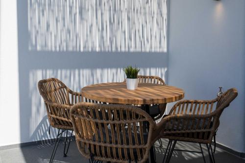 a wooden table with chairs and a potted plant on it at La Torretta Suites & Spa in Pirgos